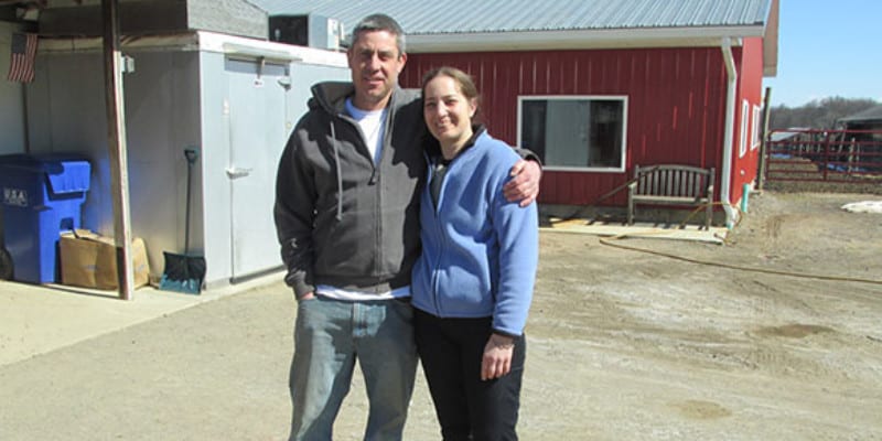 two people standing together on farm