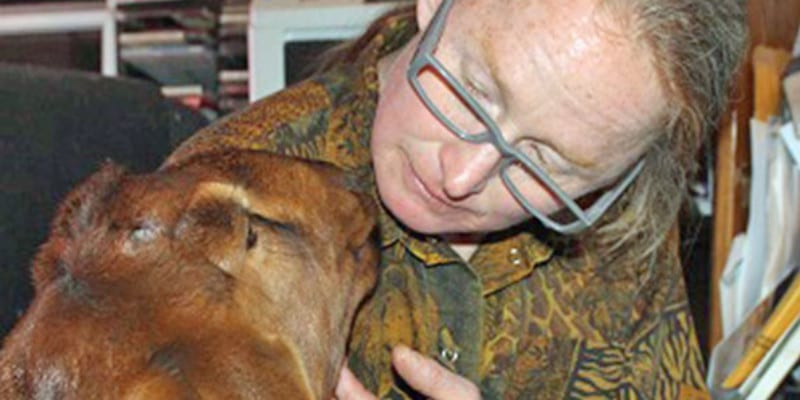 Man kissing head of goat in his house