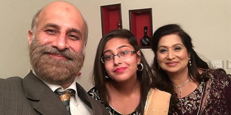 A family with a man and two women take a selfie for the camera